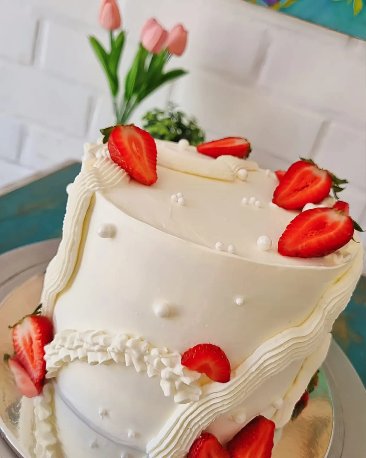 Torta blanca de crema batida con volados y frutillas frescas encima
